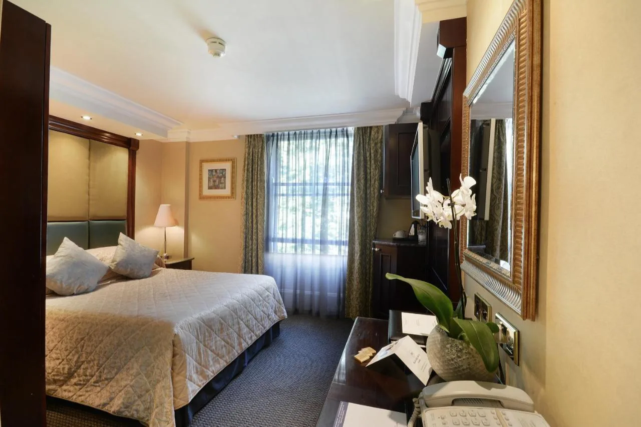 a hotel room with a bed and a mirror at The Premier Notting Hill in London