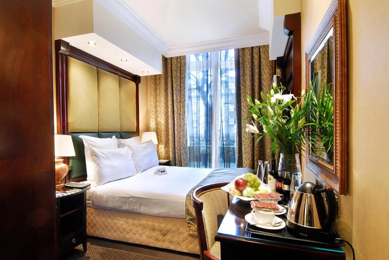 a hotel room with a bed and a table with a plate of food at The Premier Notting Hill in London